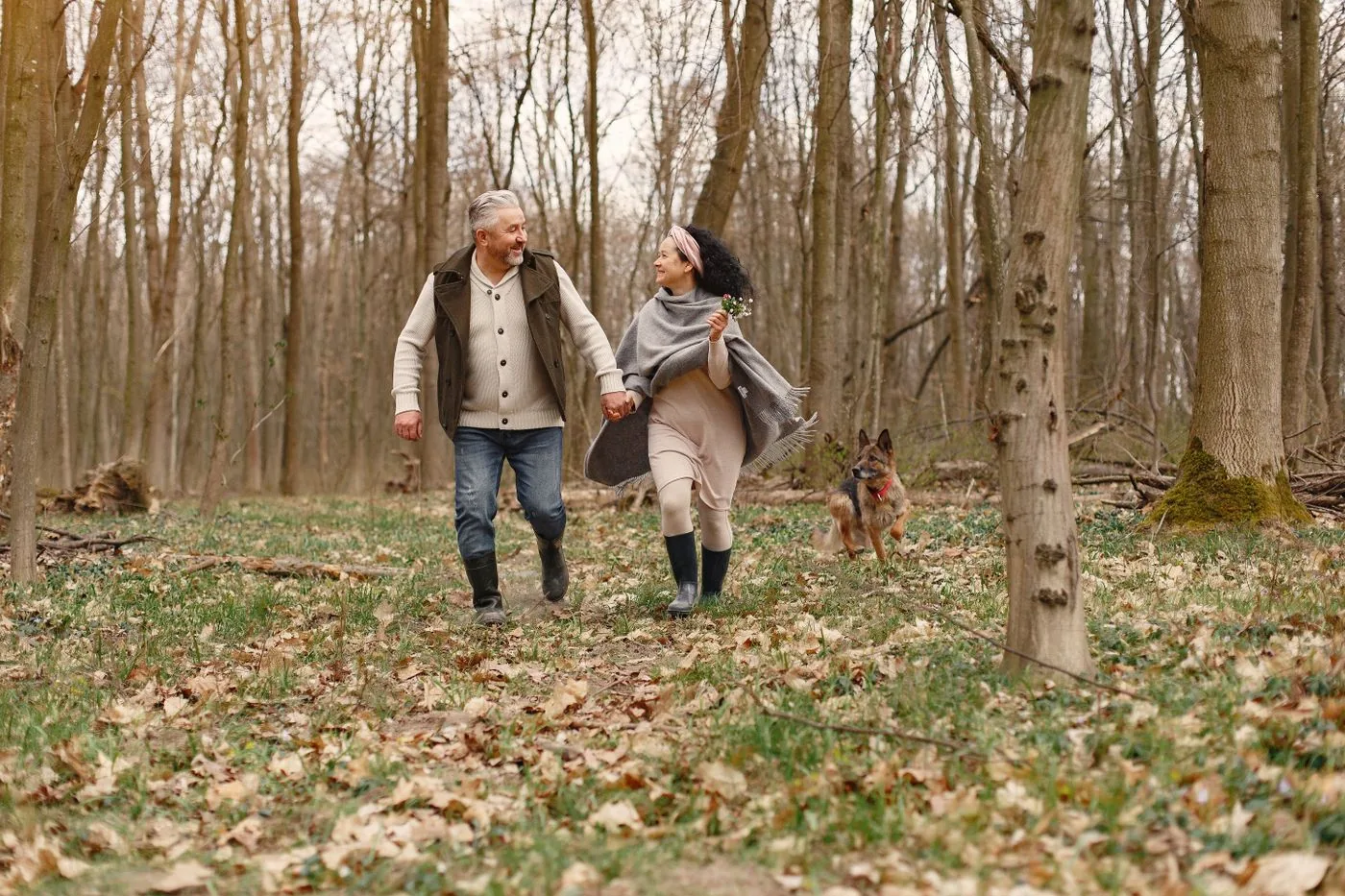 An older adult walking her dog with companion support nearby.